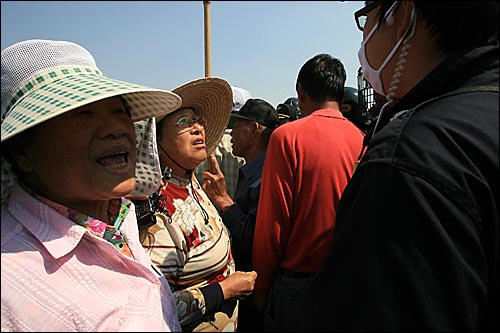 14일 오후 미군기지 확장예정지인 경기도 평택 대추리에서 한 주민이 시위진압을 위해 배치된 경찰들에게 '왜 농사를 못 짓게 하냐' '미국의 꼭두각시'라며 항의하고 있다. 